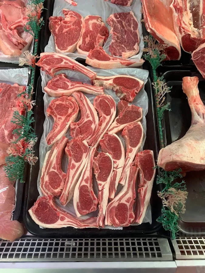 Fresh lamb chops arranged on black trays in the display counter